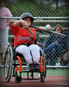 Photo of child in wheelchair hitting a baseball