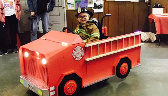 Boy in Wheelchair decorated as a Fire Truck for Halloween