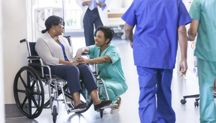 Nurse Talking to Woman in Hospital Wheelchair
