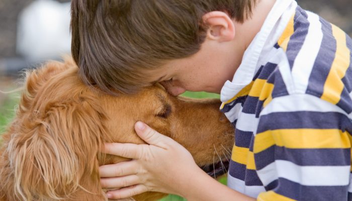 Little boy hugging a Golden Retriever dog