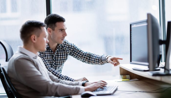 Two Men in Office Looking at a Computer
