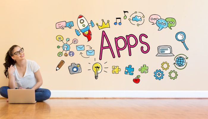 Young Woman with laptop looking at Apps graphics