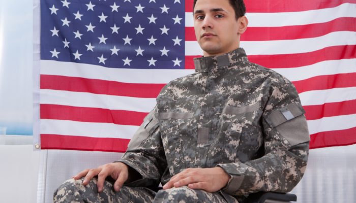 Veteran in Wheelchair in front of an American Flag